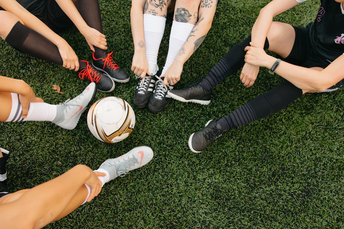 Free Legs Surrounding a Soccer Ball Stock Photo
