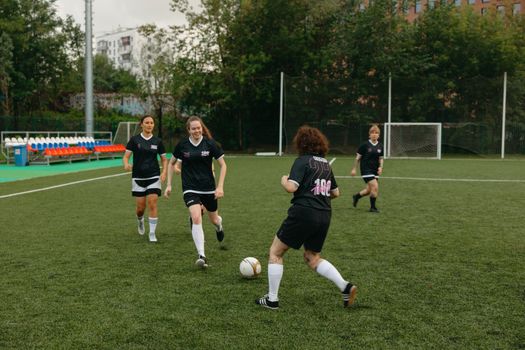 Women soccer players competing on an outdoor field during the day.