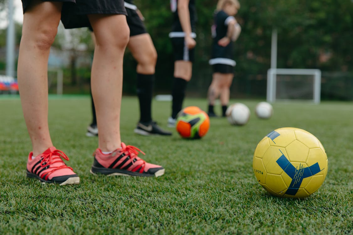 Photo of soccer players practicing on kicking the soccer ball