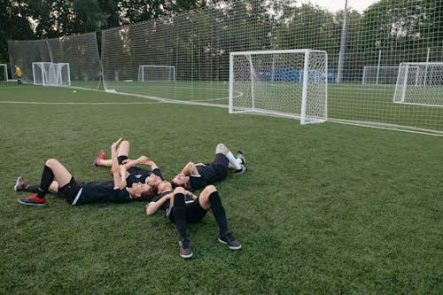 Athletes Lying Down on Grass