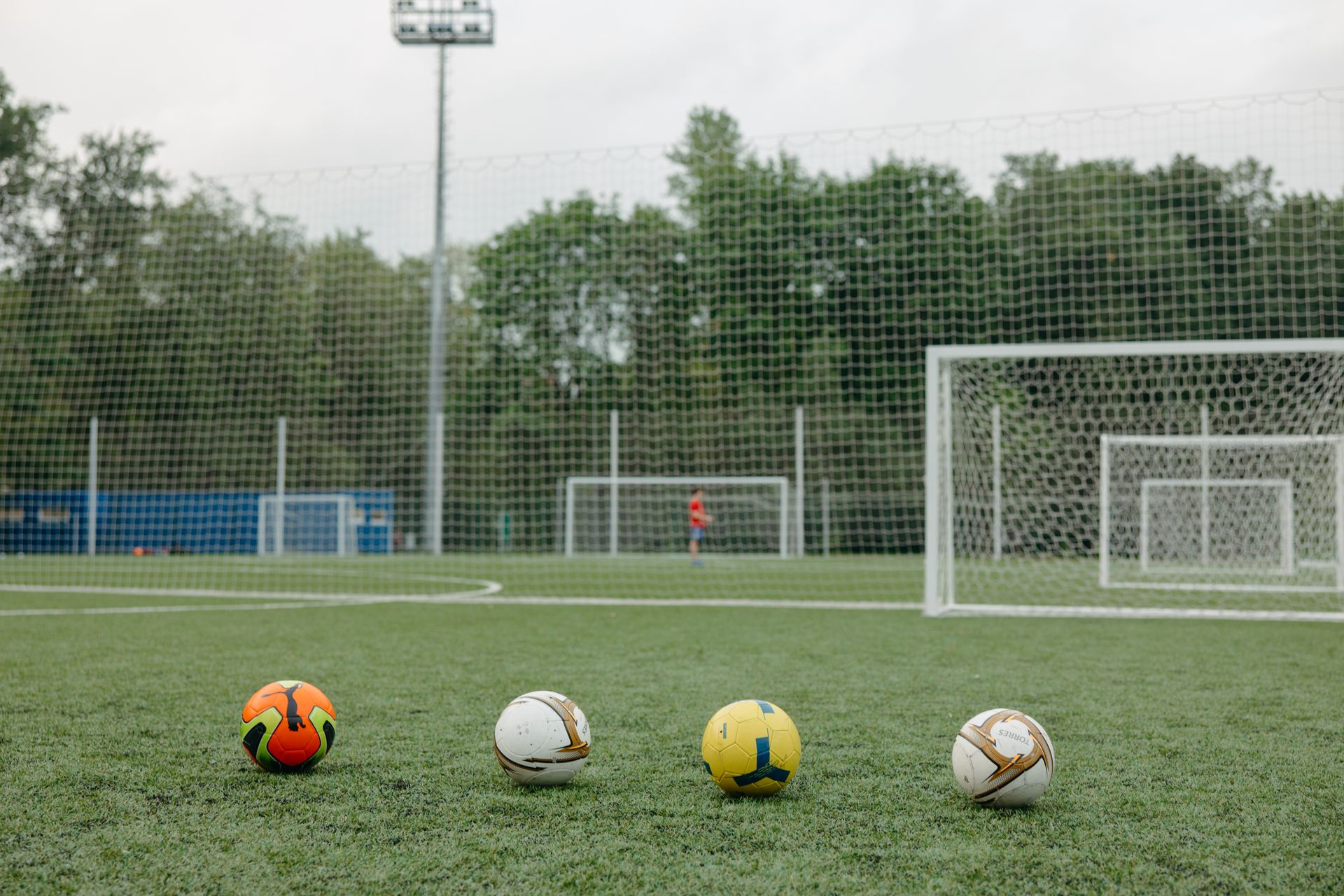 Akşam ışığında bir futbol antrenman sahası ve kale direği.