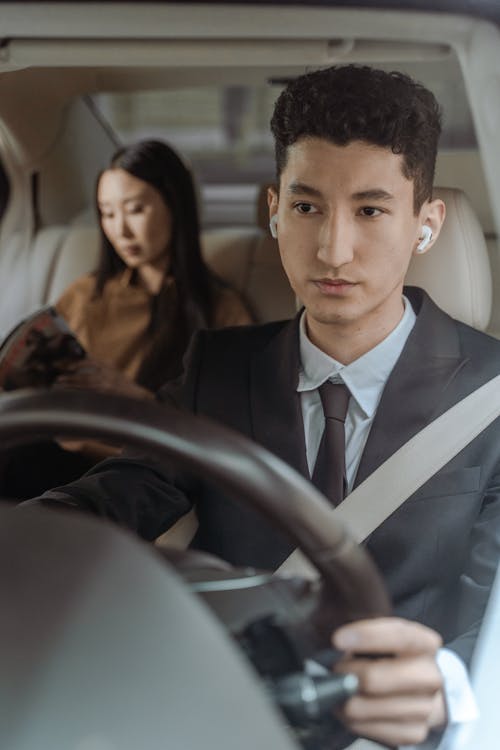 Close-Up Shot of a Man in Black Suit Driving a Car