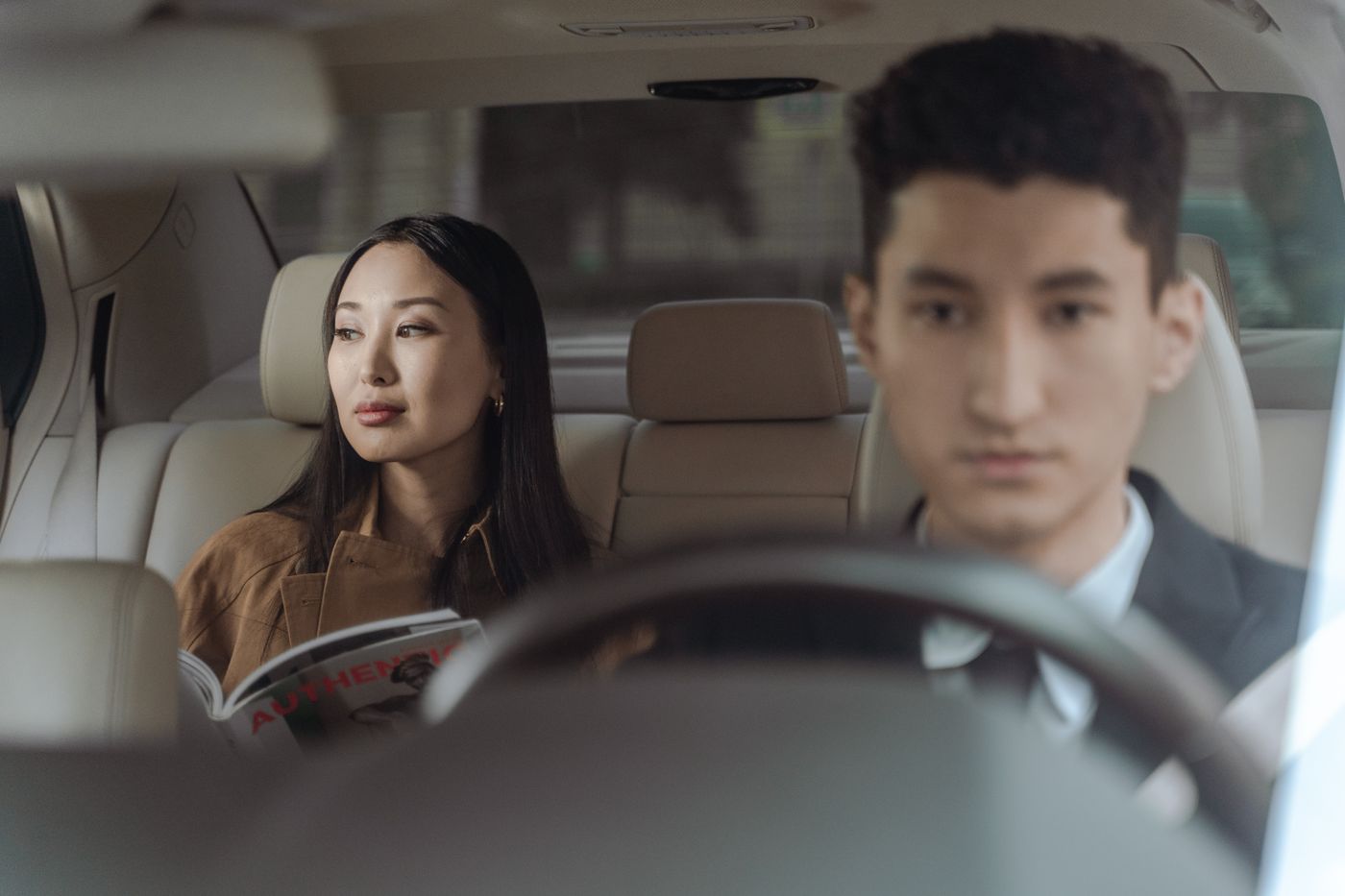 乘客坐在車內後座，司機正在駕駛接送車輛