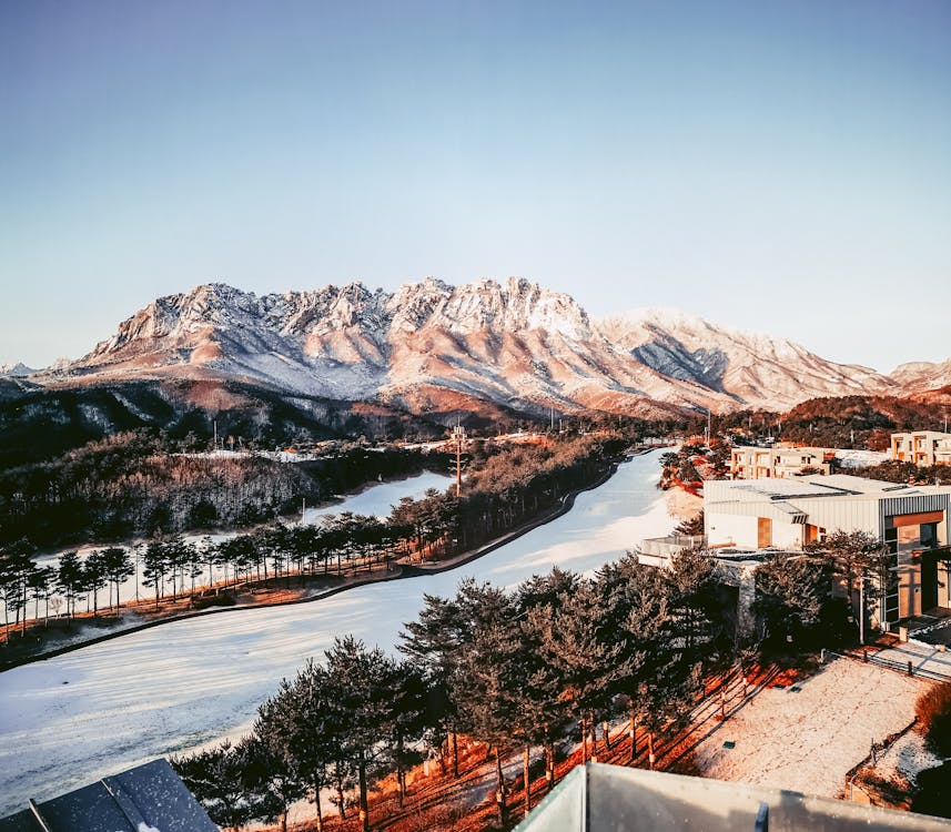 An Aerial Photography of a Snow Covered Mountain Under the Clear Sky