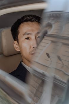 Businessman in a car looking through the window with an elegant expression.