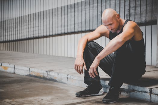 Man Sitting on Sidewalk