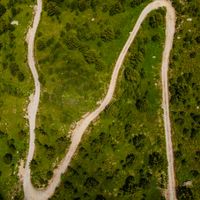 Winding off-road trail through green hills — Micko Damnjanovski on Pexels