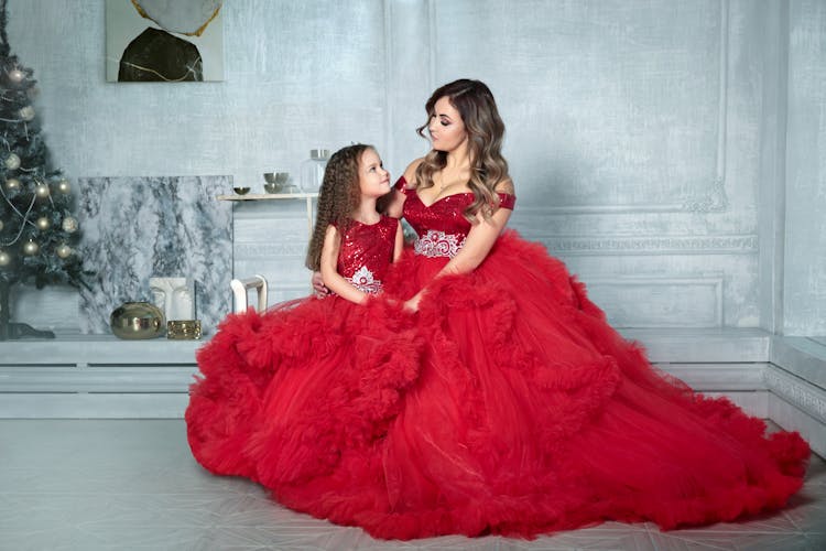 Mother And Daughter In Gowns Posing In Studio