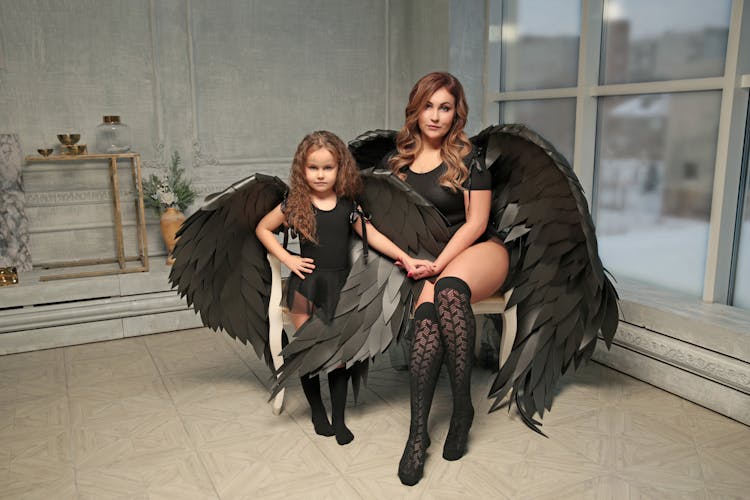 Mother And Daughter With Black Wings In Studio