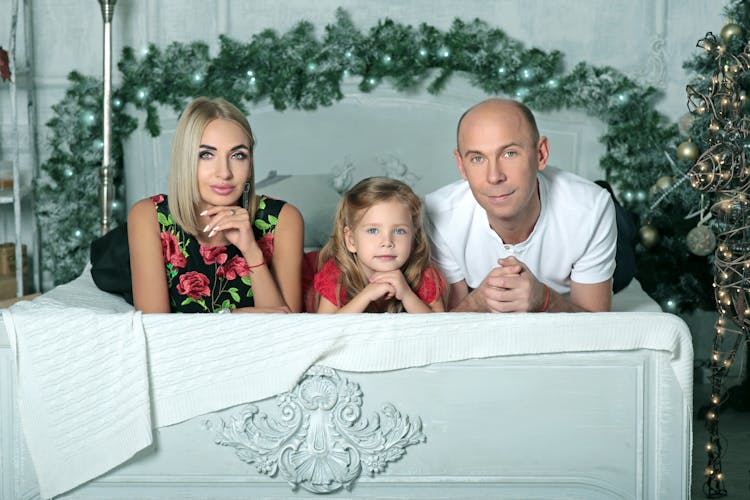 Family Posing On The Background Of Christmas Decorations