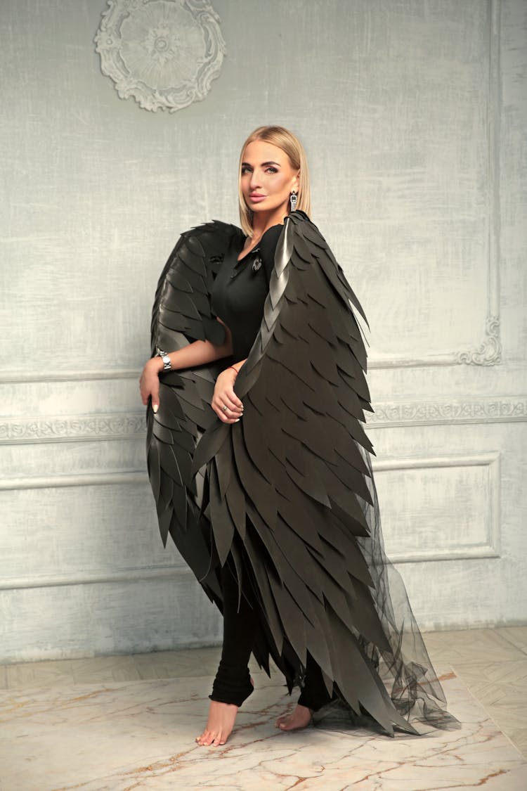 Blonde Woman In A Costume With Black Wings 