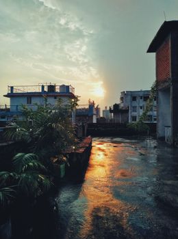Rooftop view in Patna capturing the sunset reflecting on wet surfaces.