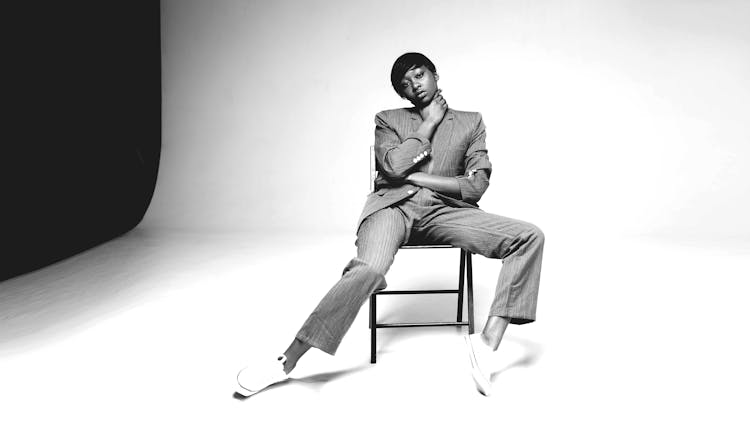 Grayscale Photo Of Person Sitting On Chair