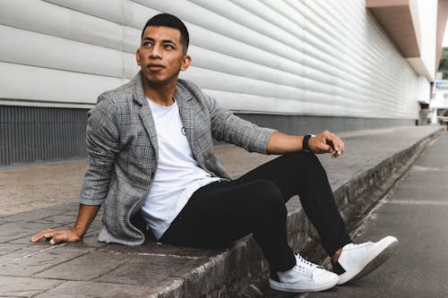 Free Man in Gray Checkered Blazer and Black Pants Sitting on Concrete Pavement Stock Photo