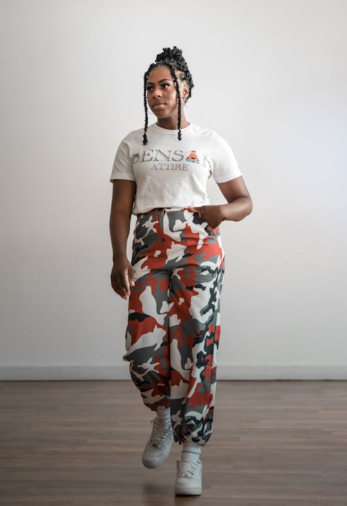 Photo of a Woman Wearing Camo Pants and a White Crew Neck Shirt