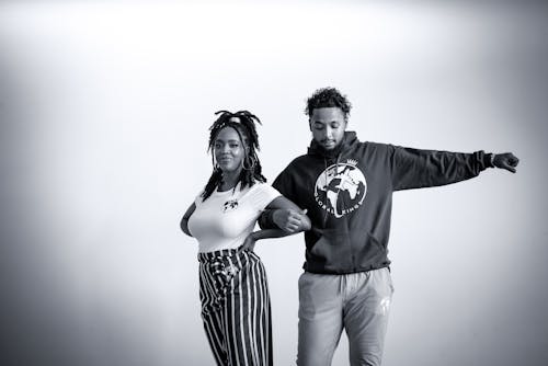 Grayscale Photo of Man and Woman Standing Close Together 