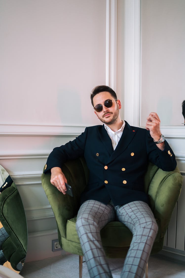 Man Wearing Sunglasses Sitting On Green Accent Chair 