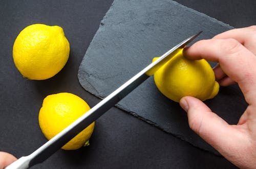 Human Slicing Yellow Lemon