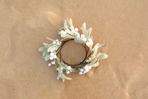 Free A decorative holiday wreath placed on sand, symbolizing Christmas at the beach. Stock Photo