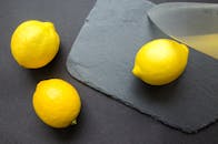 将三个新鲜柠檬放在石板上，用刀切开，以凸显柑橘的新鲜度