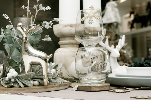 Free A cozy holiday table setup featuring decorative reindeer, candles, and festive ornaments. Stock Photo