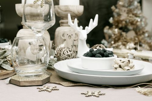 Free Beautiful holiday table setting with blueberries, glassware, and reindeer decor for festive celebrations. Stock Photo