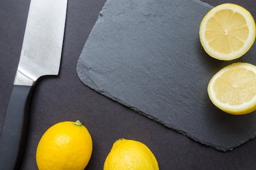 Fotografi Irisan Lemon Dekat Pisau Dapur