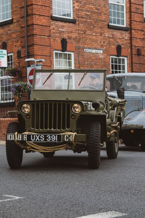 Free A classic military Jeep on a city street, showcasing vintage transportation in an urban environment. Stock Photo