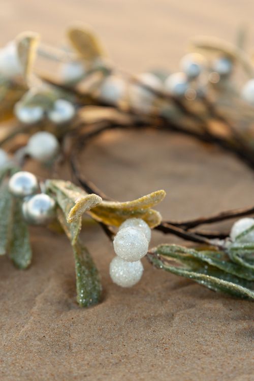 Free Close-up of a mistletoe garland on sand, perfect for Christmas decoration. Stock Photo