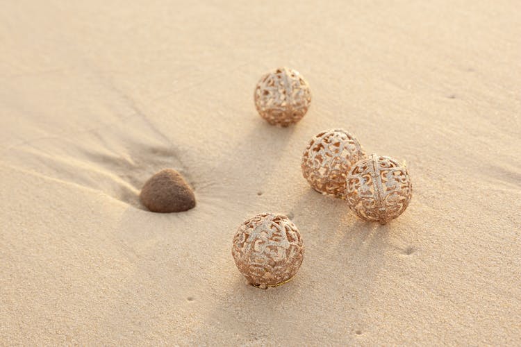 Gold Christmas Baubles On The Beach 
