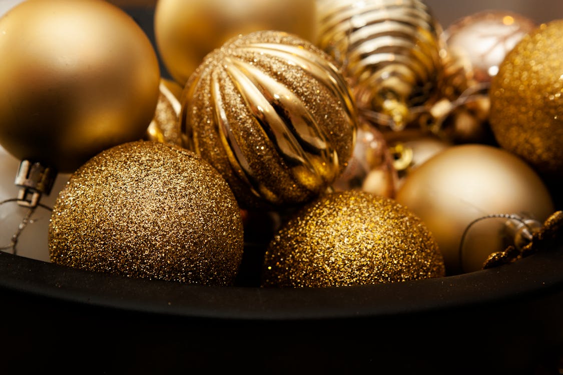 A Bucket of Gold Christmas Baubles in Close-up Photography