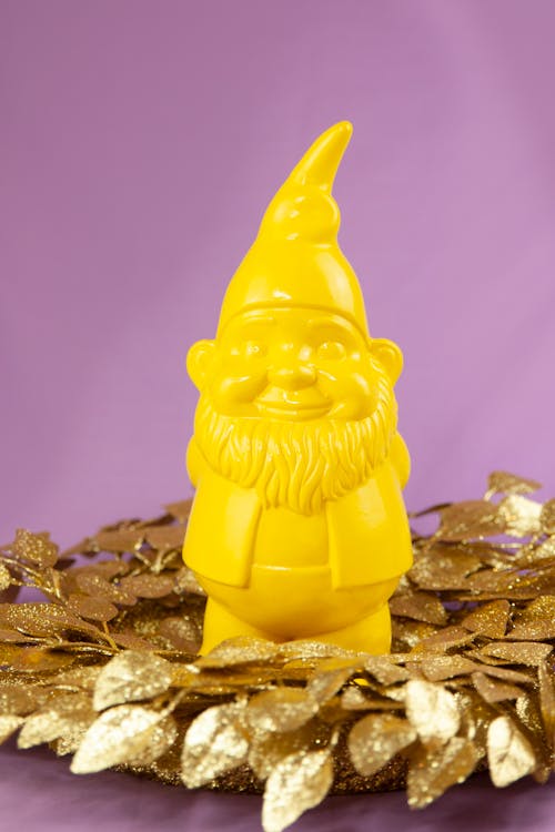 Figurine of Yellow Dwarf Standing on Golden Leaves Decoration