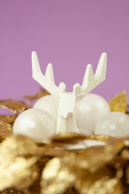 A White Reindeer Figure over a Golden Wreath