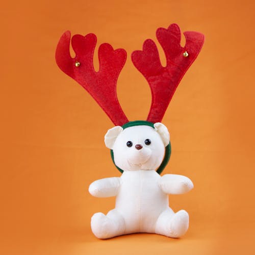 A Stuffed Teddy Bear with Reindeer Headband