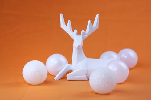 Photograph of a Deer Figurine Near White Balls