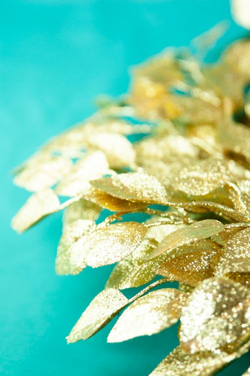 Free A vibrant close-up of sparkling gold leaves on a teal backdrop, perfect for decoration themes. Stock Photo