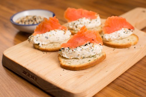 Bread with Smoked Salmon and Cottage Cheese on a Cutting Board 