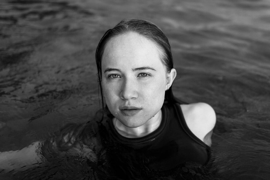 Artistic black and white portrait of a woman floating in water.