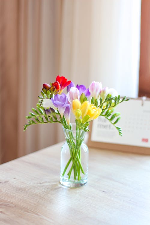 Pink and Yellow Flowers in Clear Glass Vase
