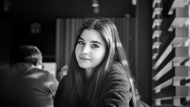 Elegant portrait of a young woman with natural light inside a modern venue., free online jigsaw puzzle on JigsawPuzzlesFreeOnline.org