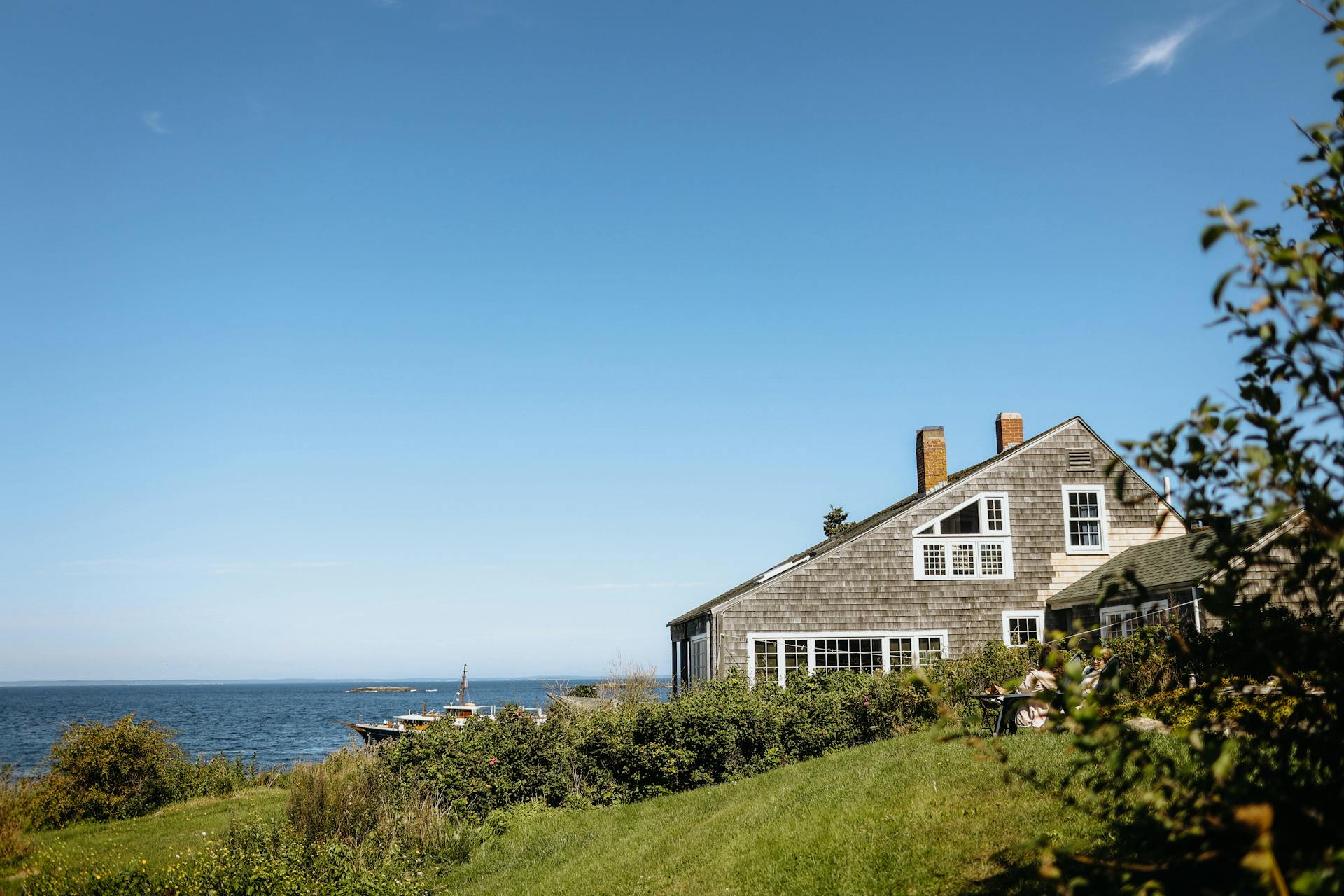 A picturesque coastal house in Monhegan, ME, with stunning ocean views captured on a sunny day.