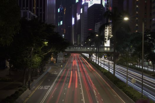 Captivating Hong Kong cityscape at night featuring vibrant light trails and towering skyscrapers.