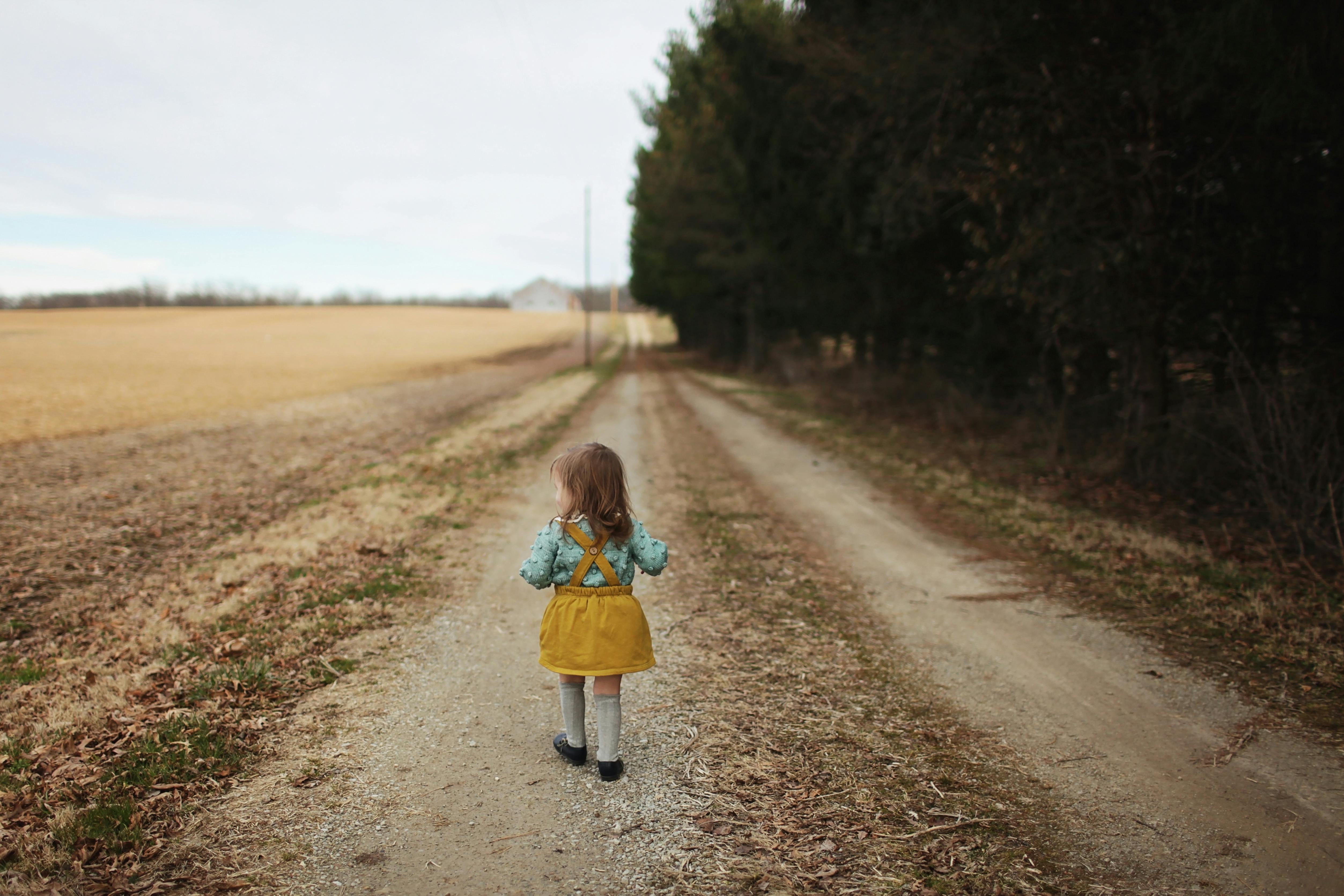 Mädchen läuft Feldweg hinunter | Quelle: Pexels