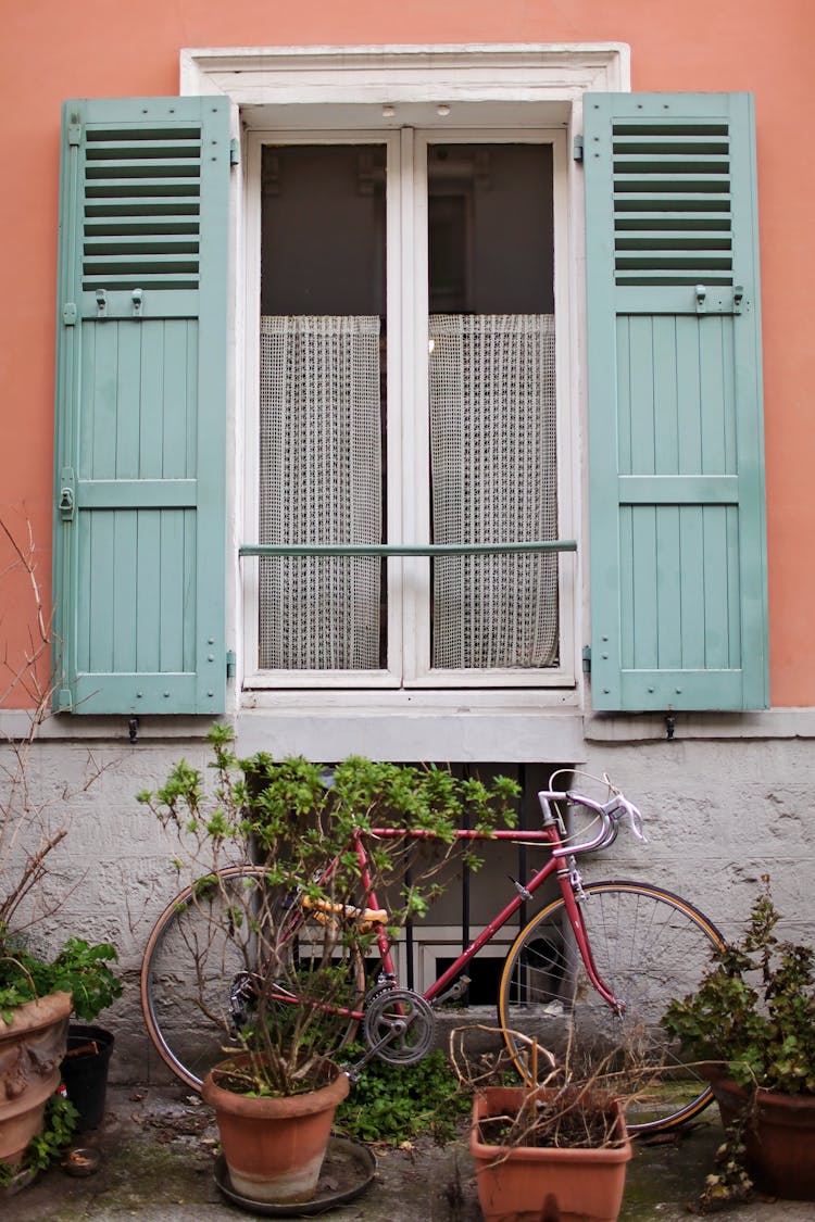 Window With Green Shutters On Peach Colored House In Paris