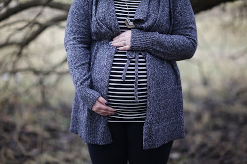 Vrouw Zwanger In Zwart Wit Gestreepte Shirt Permanent In De Buurt Van Kale Boom