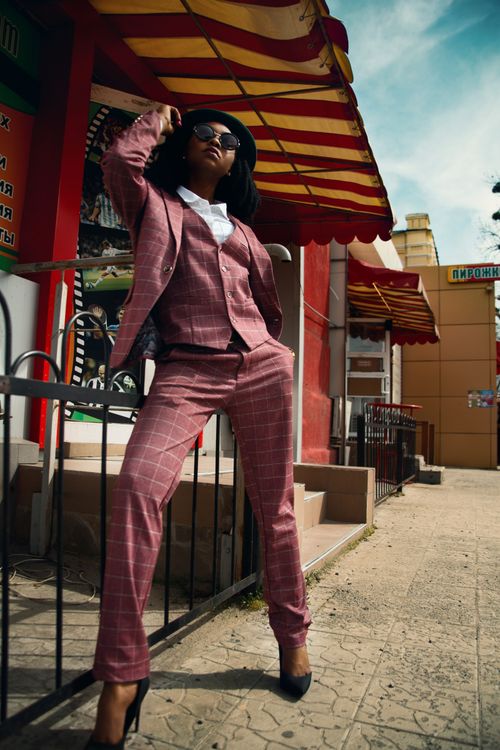 Free Fashionable young woman in a plaid suit posing confidently outdoors in an urban setting. Stock Photo