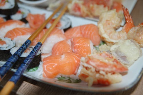 Eetstokjes Bovenop Verscheidenheid Van Sushi Op Plaat