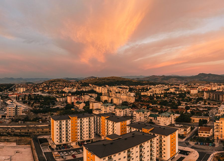 Scenic aerial view of Podgorica, Montenegro at sunset featuring vibrant skies and urban architecture.