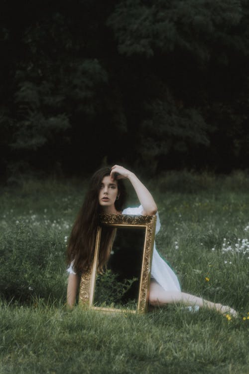 Woman in White Dress Sitting on Grass Field