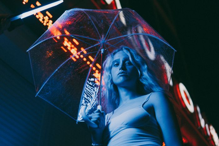 Portrait of a woman under umbrella with neon lights in the city at night., by Anastasia Bekker on Pexels